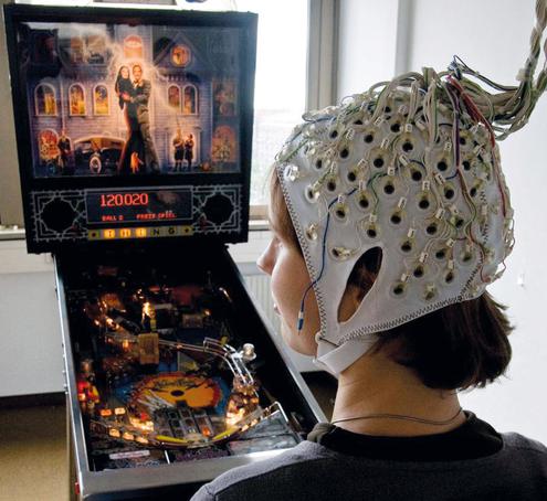 Eine Frau steuert einen Flipper mit einem Brain Computer Interface (Bild: TU Berlin und BBC)