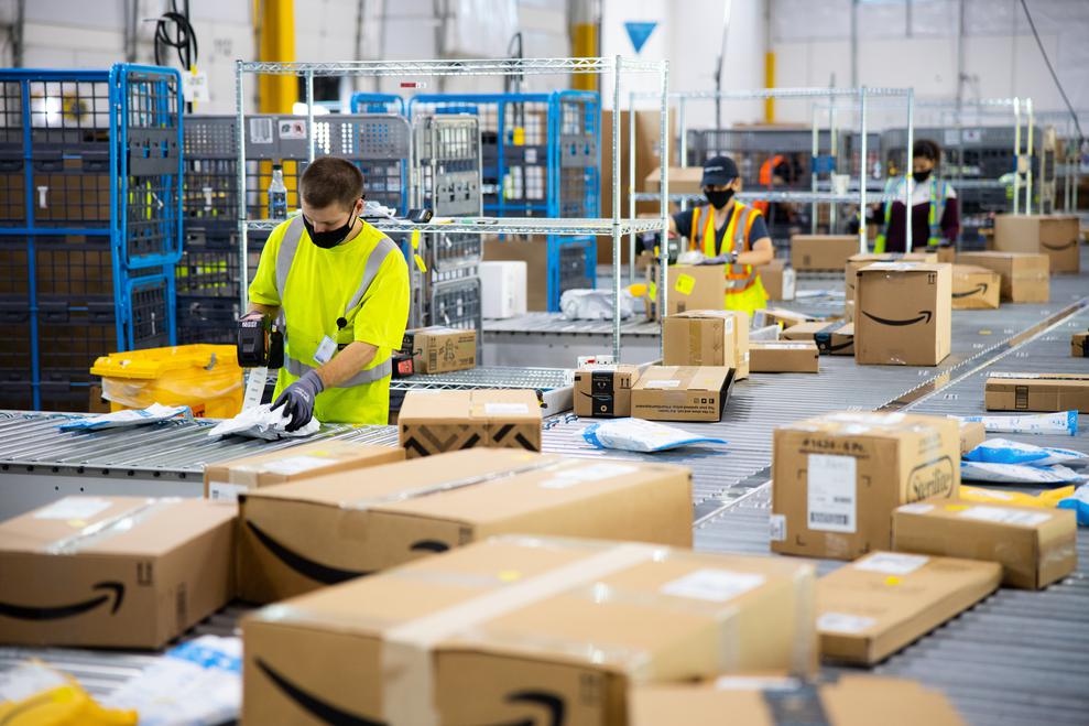 Mehr zu tun in der Coronakrise: Amazon-Mitarbeiter mit Mundschutz. (Bild: Amazon)